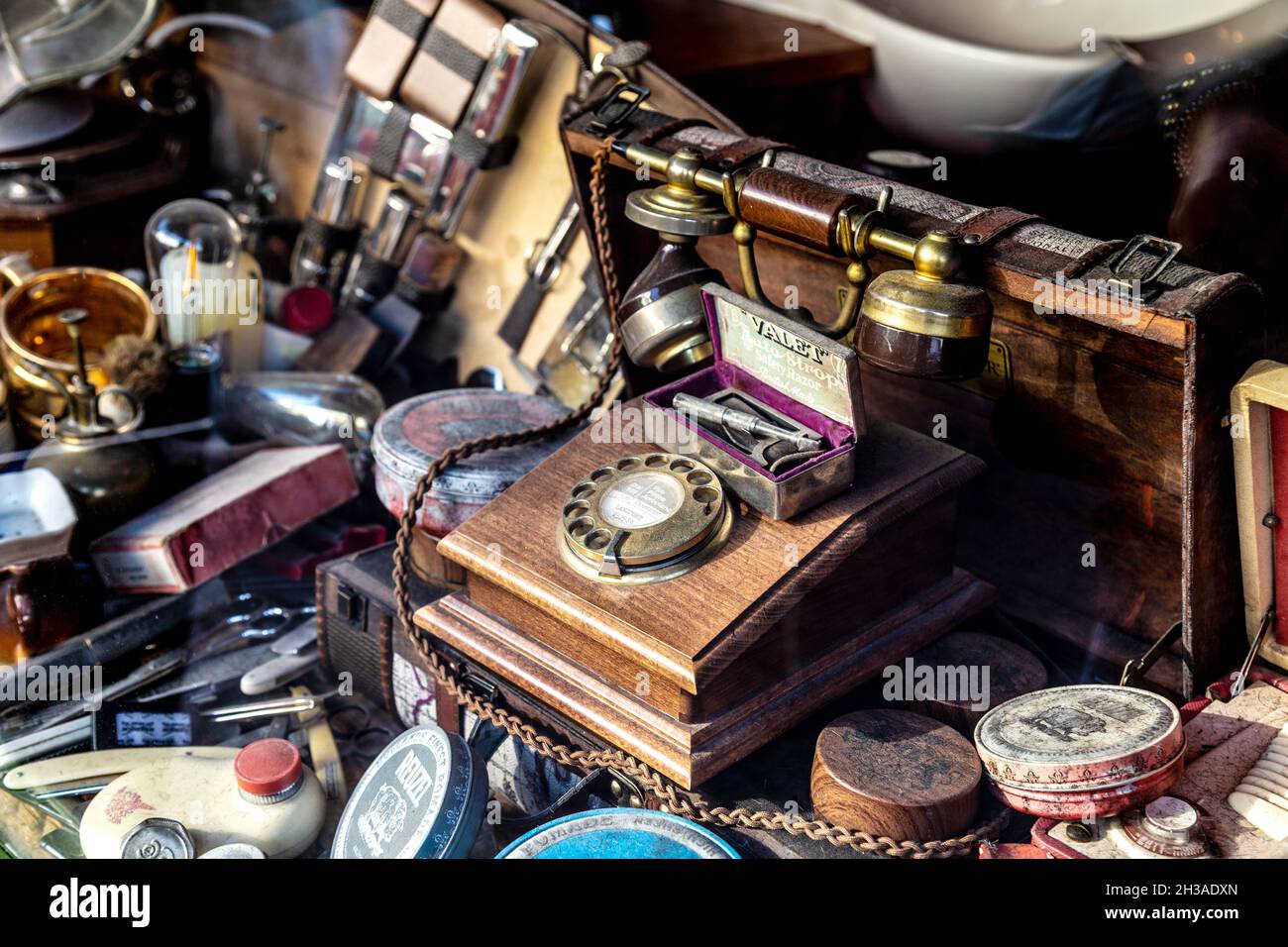 Display of vintage and retro babrer shop accessories, razors, hair products and rotary telephone (Palace Barber, East Molesey, London, UK) Stock Photo