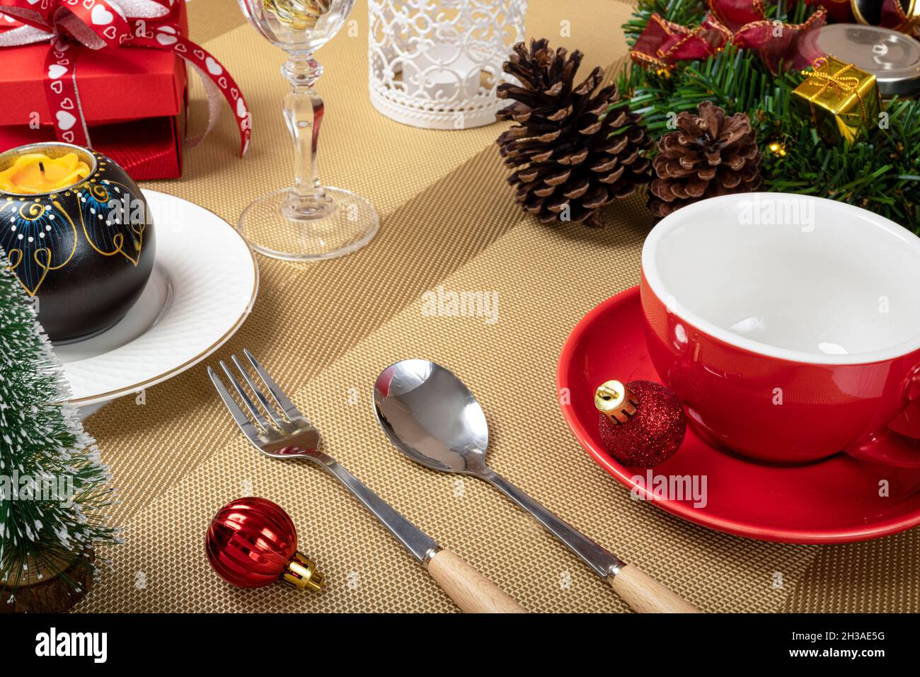 Christmas dinner table decorations with a red ceramic coffee cup. Stock Photo