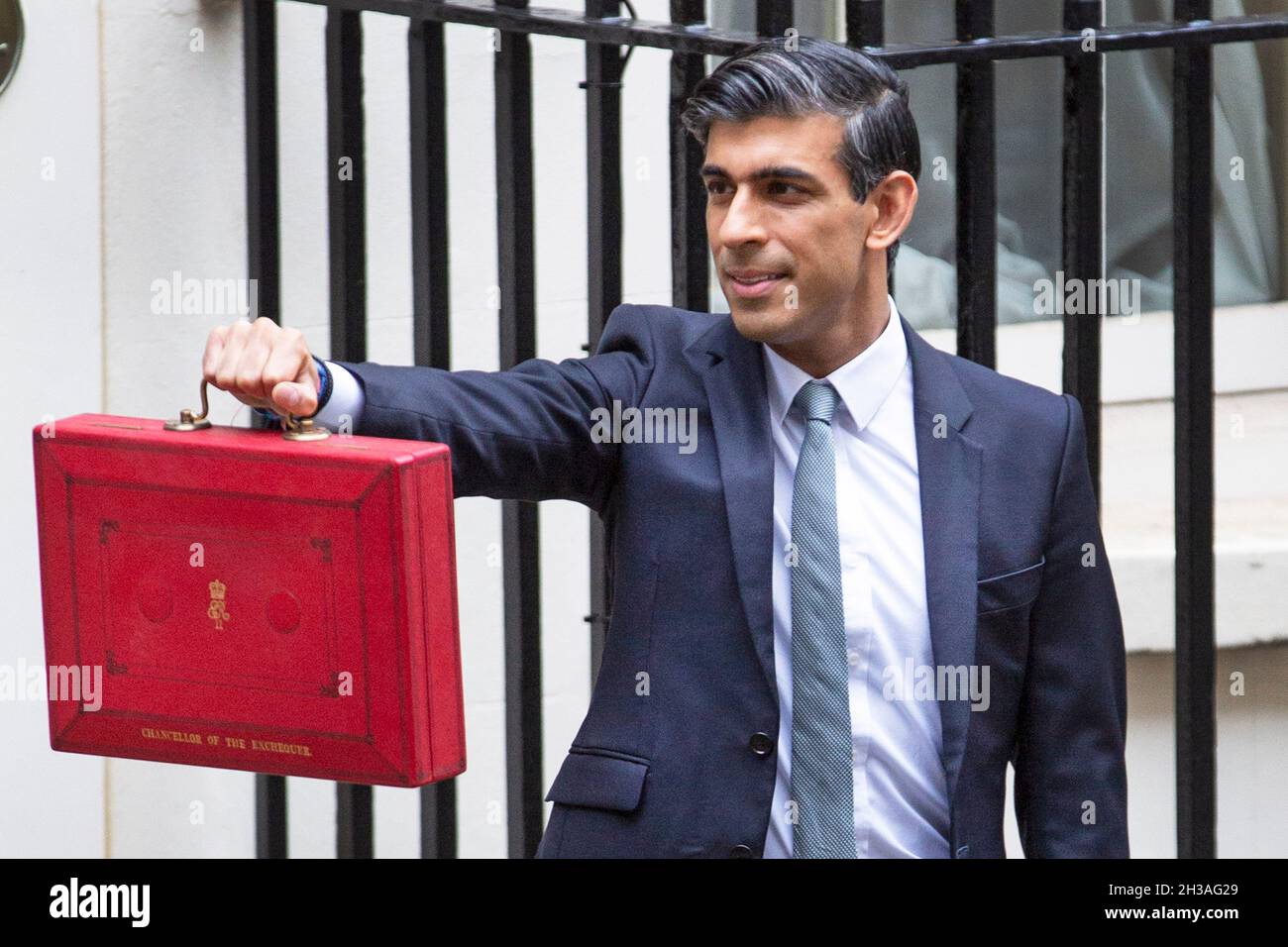Chancellor Rishi Sunak holds up the Red Box that contains the autumn Budget before he leaves No 11 Downing Street on October 27th 2021 for the House o Stock Photo