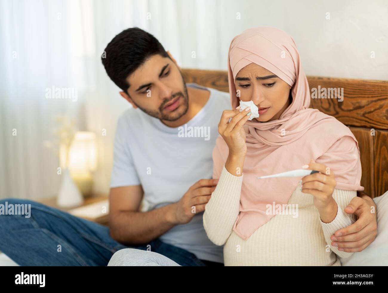Illness during pregnancy. Loving muslim husband taking care about his sick pregnant wife, woman