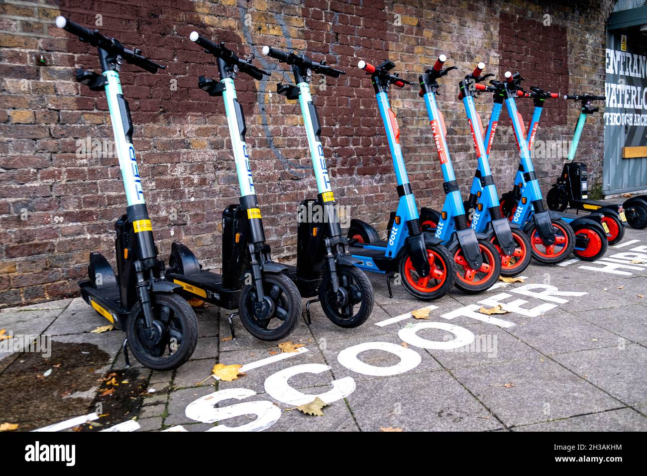 A Parked Row Of Environmentally Friendly Green Electric Scooters For Hire By The Public At