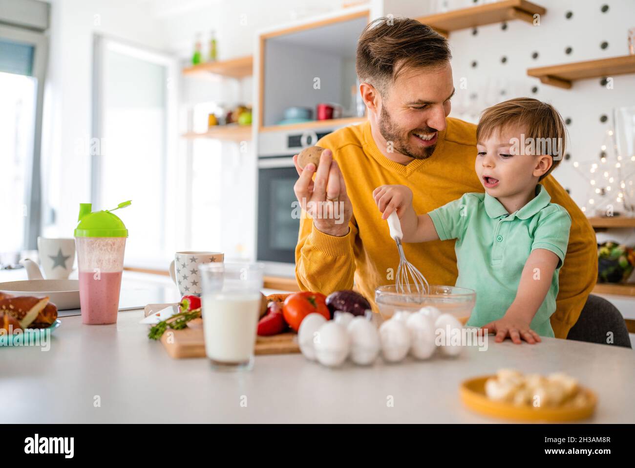 Smiling father with kids preparing healthy food and spending time together Stock Photo
