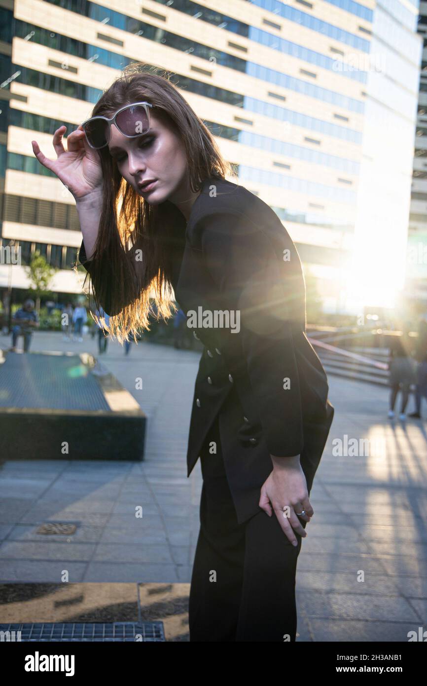 Young business woman on the street of a modern city with dark glasses ...