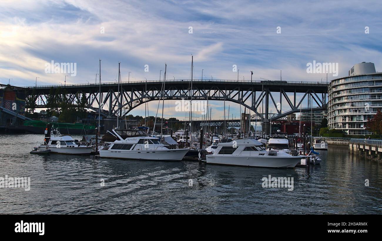 View of Granville Street Bridge in Vancouver downtown spanning False Creek bay with marina and yacht boats in front in the afternoon light. Stock Photo