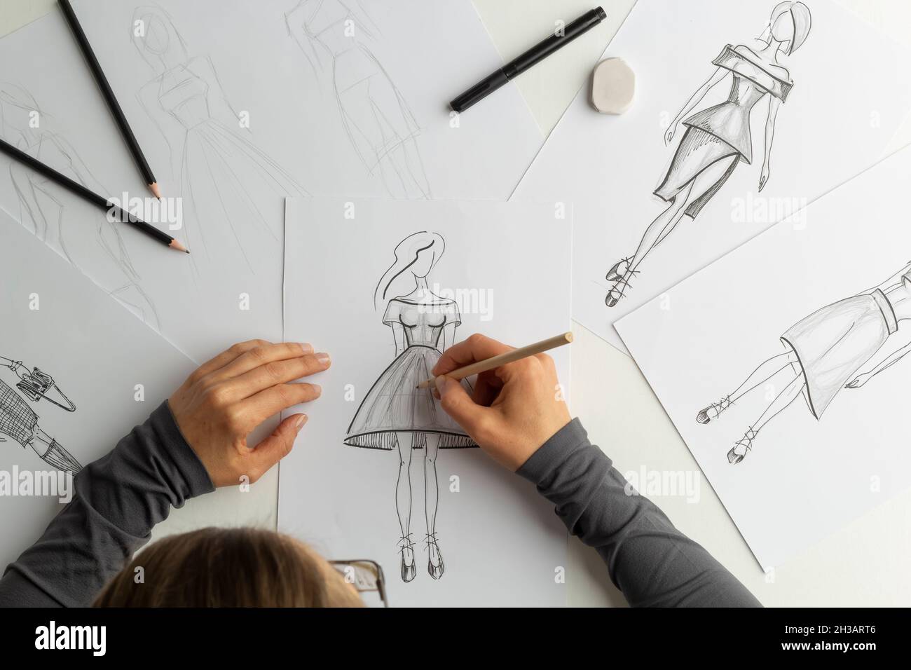 The designer draws sketches of women's dresses on paper Stock Photo - Alamy The designer draws sketches of women's dresses on paper Stock Photo - Alamy