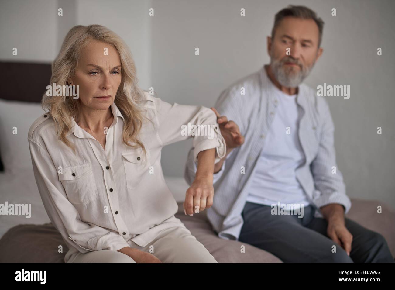 Displeased lady paying no attention to her husband Stock Photo
