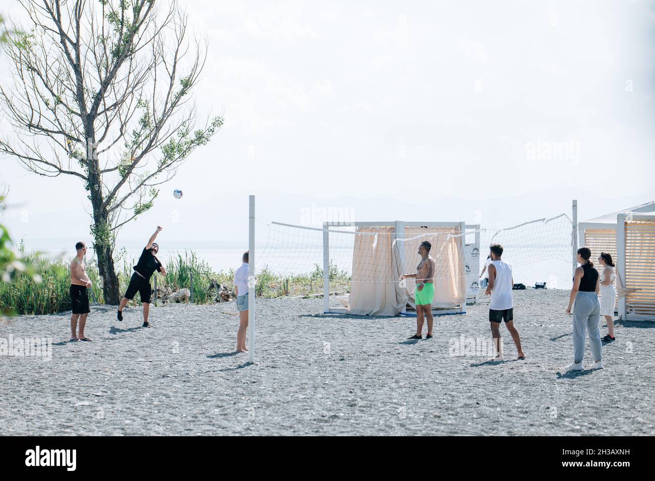 SEVAN, ARMENIA - Sep 03, 2021: A group of young people playing volleyball on the beach at Lake Sevan, Armenia Stock Photo