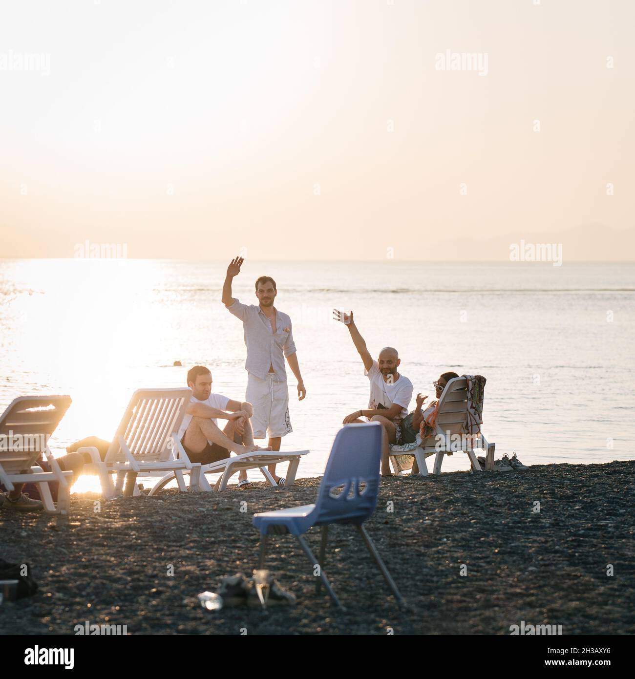 SEVAN, ARMENIA - Sep 03, 2021: A group of young people enjoying the beach party on the shore of Lake Sevan at sunset Stock Photo
