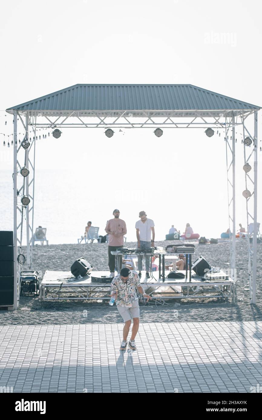 SEVAN, ARMENIA - Sep 03, 2021: A group of young people enjoying the beach party on the shore of Lake Sevan at sunset Stock Photo