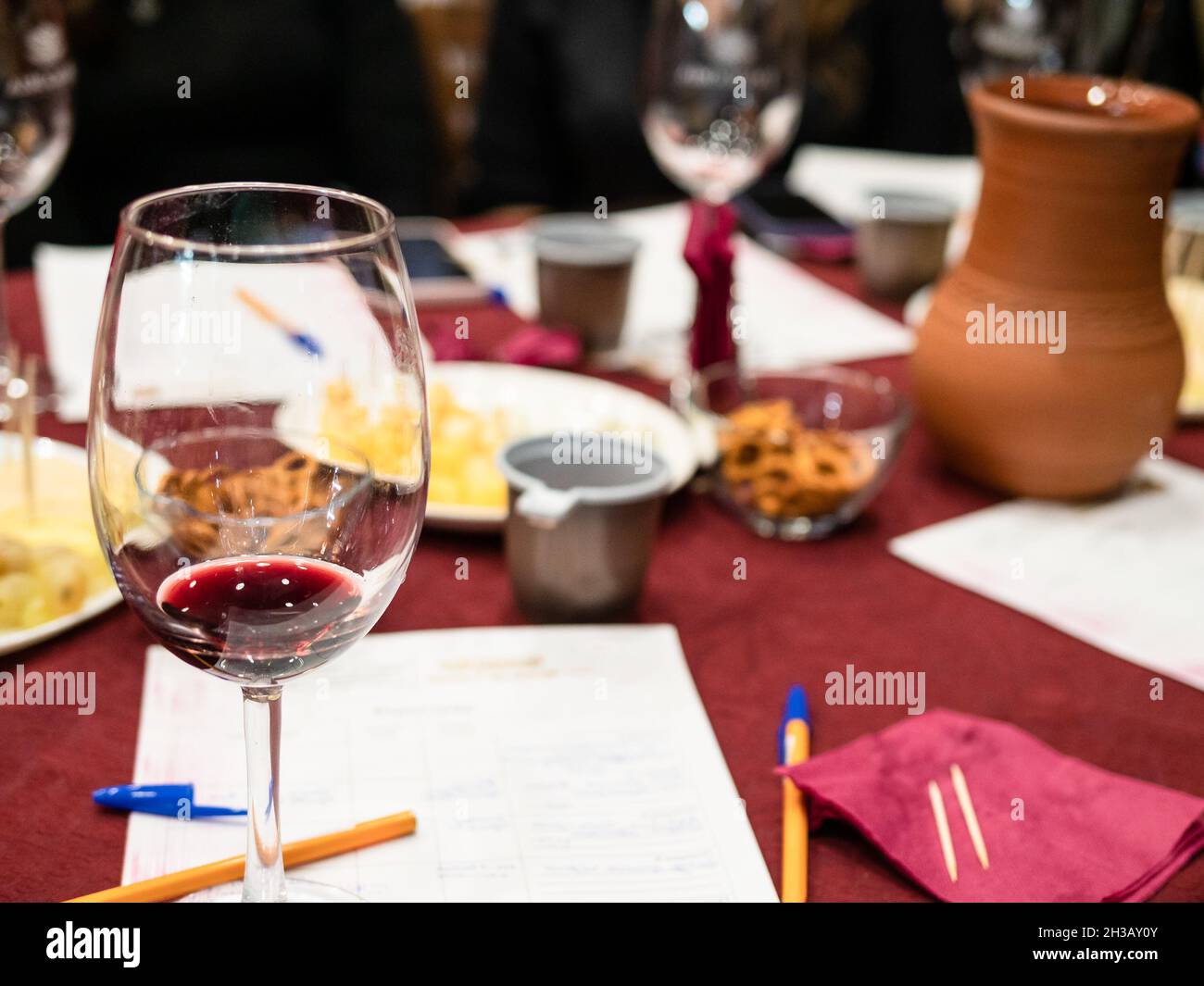 red grape wine tasting - wineglass with tested wine and written notes on table Stock Photo