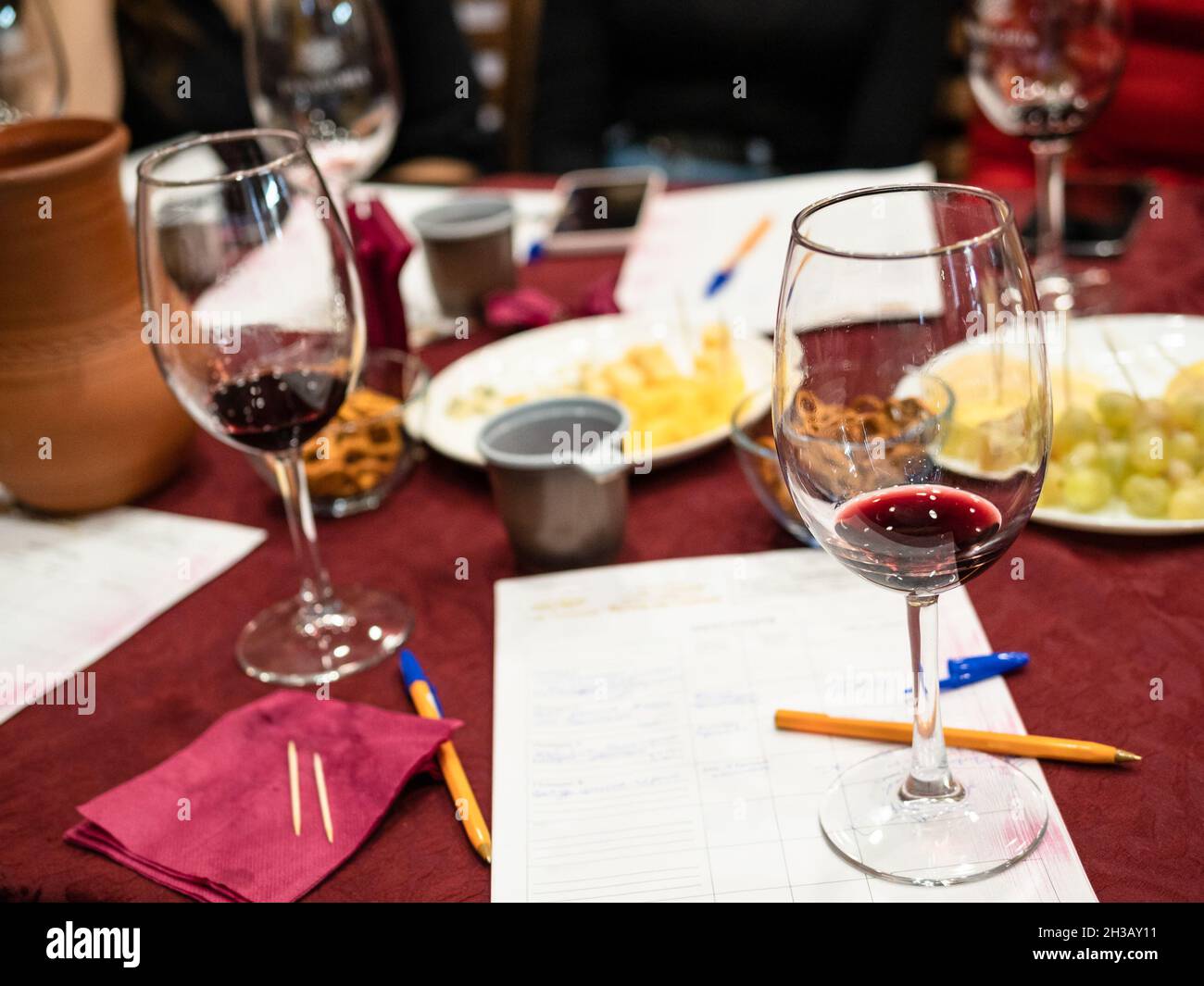 red grape wine tasting - wineglass with tested wine on notes on table Stock Photo