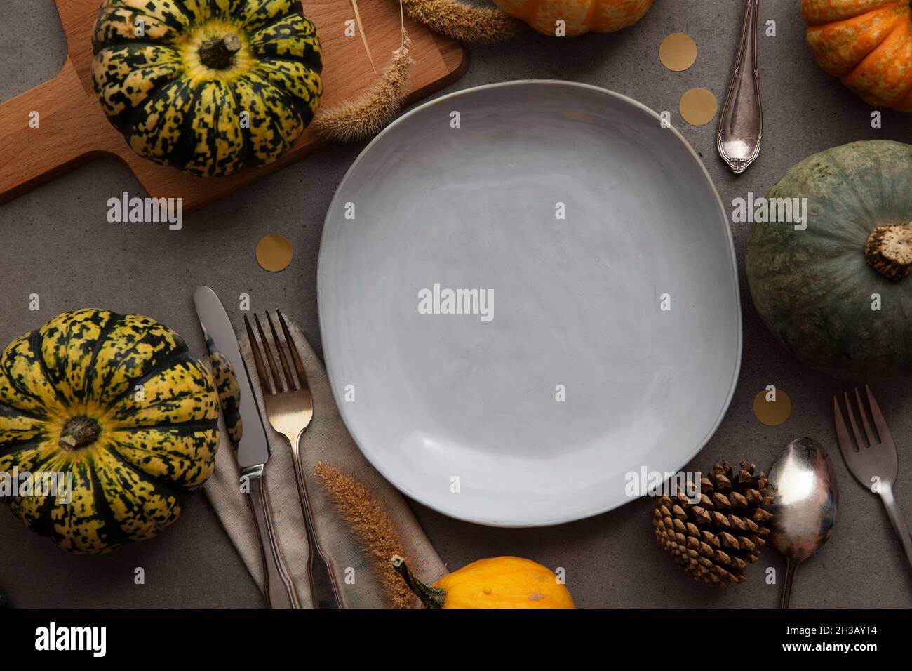 Overhead autumn thanksgiving dinner place setting with pumpkins cutlery ...
