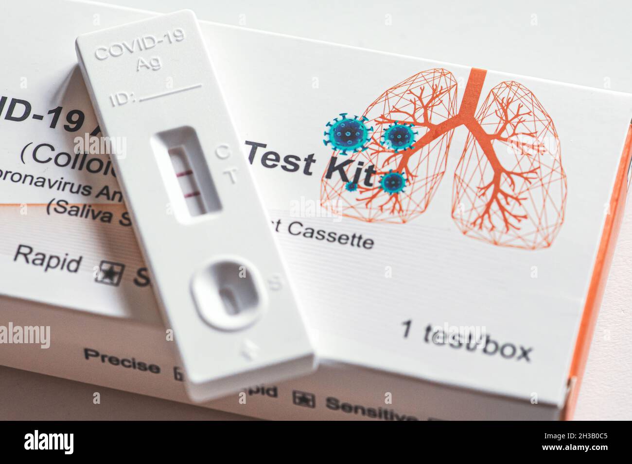 Positive Covid-19 antigen test kit, one step coronavirus antigen rapid test, saliva swab, 1 test box with imagine of lungs, close up Stock Photo