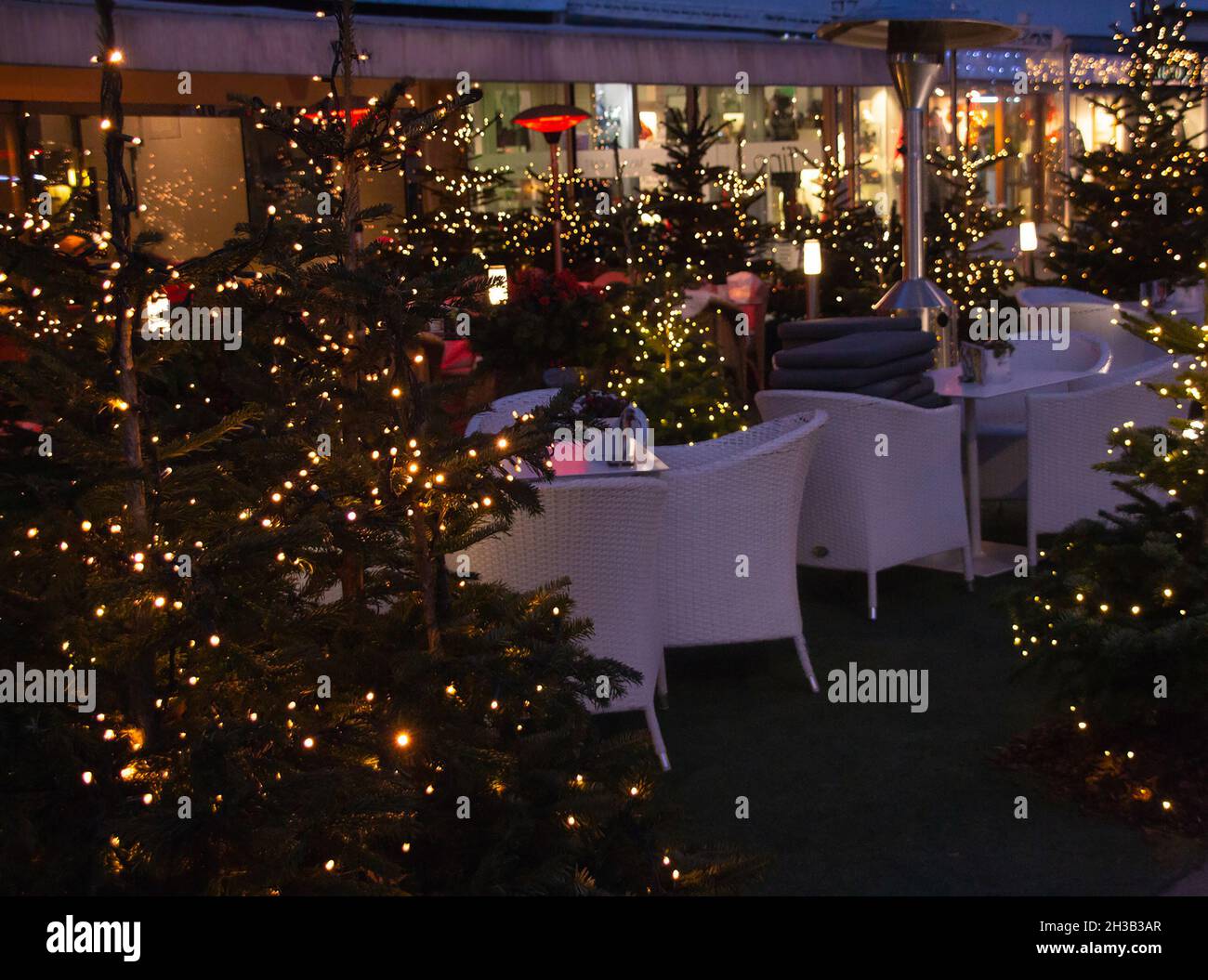 restaurant terrace decorated with christmas trees lights near traditional famous christmas market (christkindlmarkt) at Merano, South Tyrol Italy Stock Photo