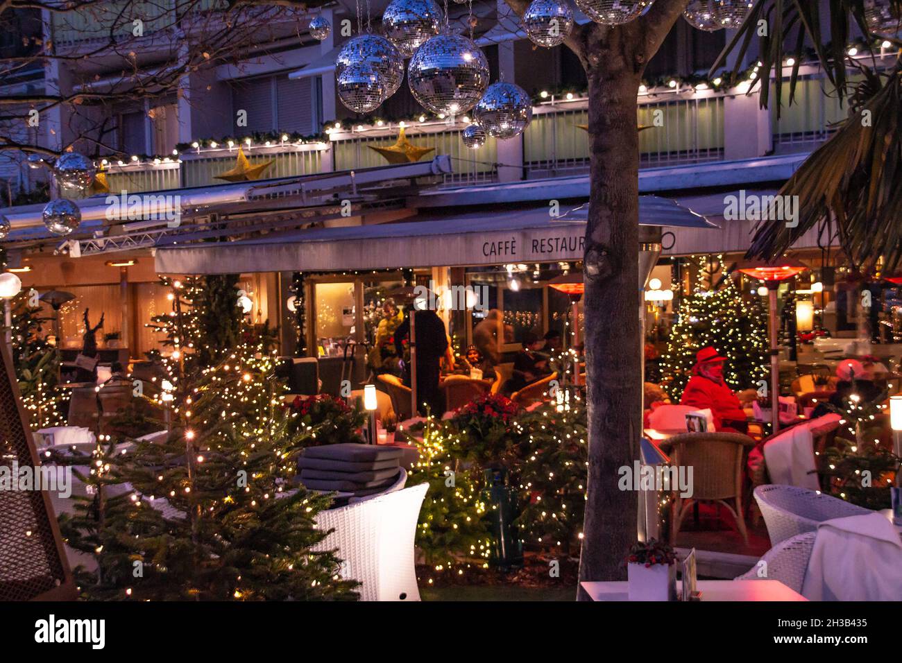 restaurant terrace decorated with christmas trees lights near traditional famous christmas market (christkindlmarkt) at Merano, South Tyrol Italy Stock Photo