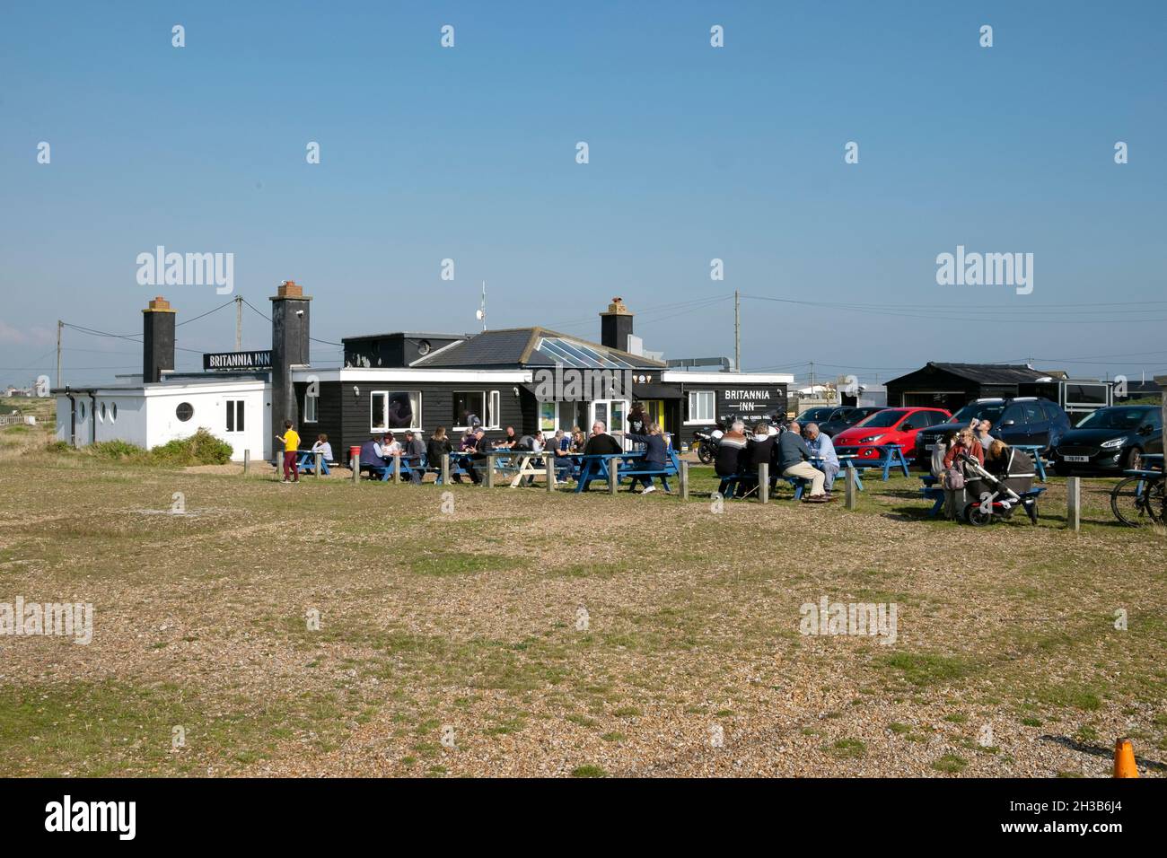 People sitting outside the Britannia pub on sunny October 2021 autumn day at picnic tables post covid pandemic in Dungeness Kent UK   KATHY DEWITT Stock Photo