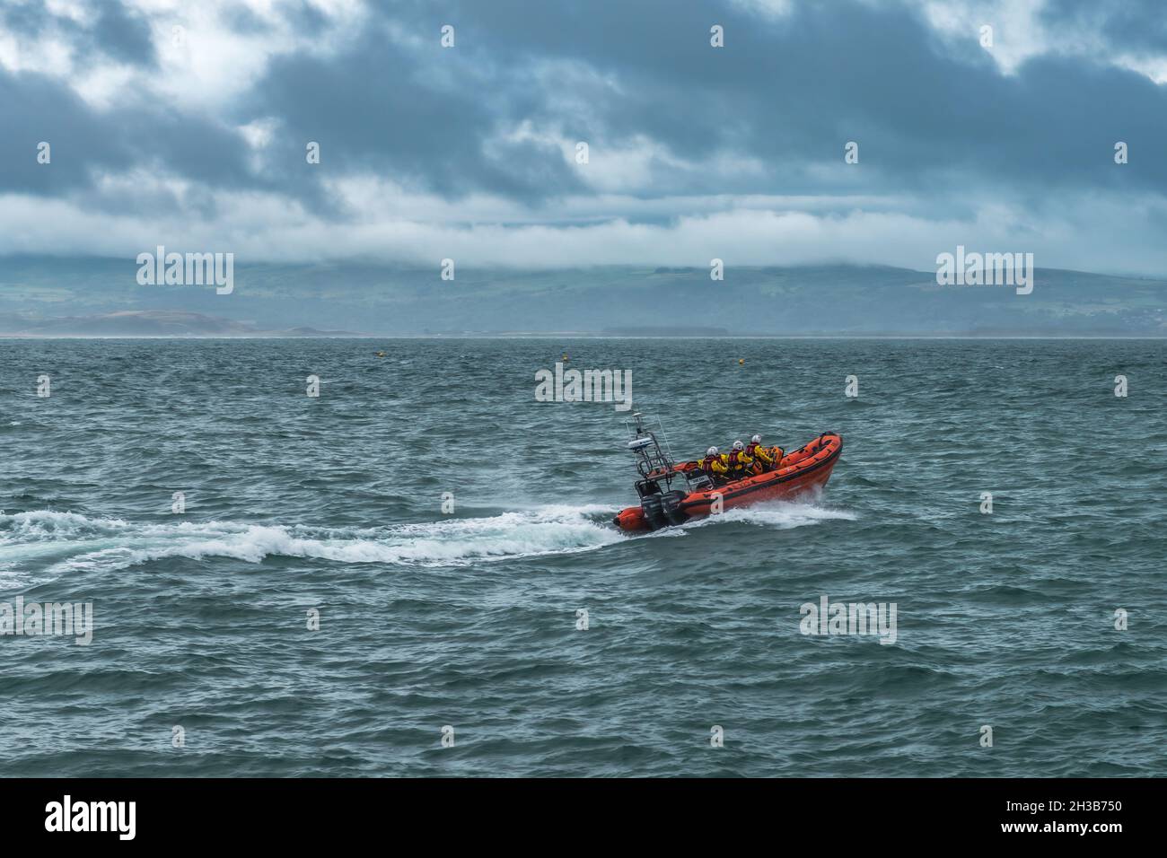 RNLI Criccieth Lifeboat Station's Atlantic 85 class lifeboat heads out to sea at speed. Stock Photo