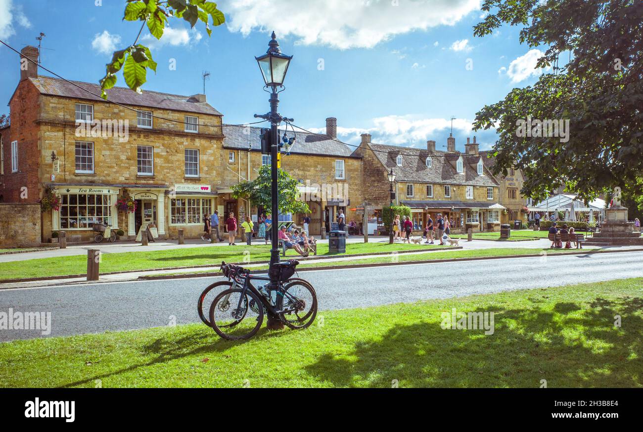 People enjoying a sunny summer day in Broadway, a village in The Cotswolds, United Kingdom. Stock Photo