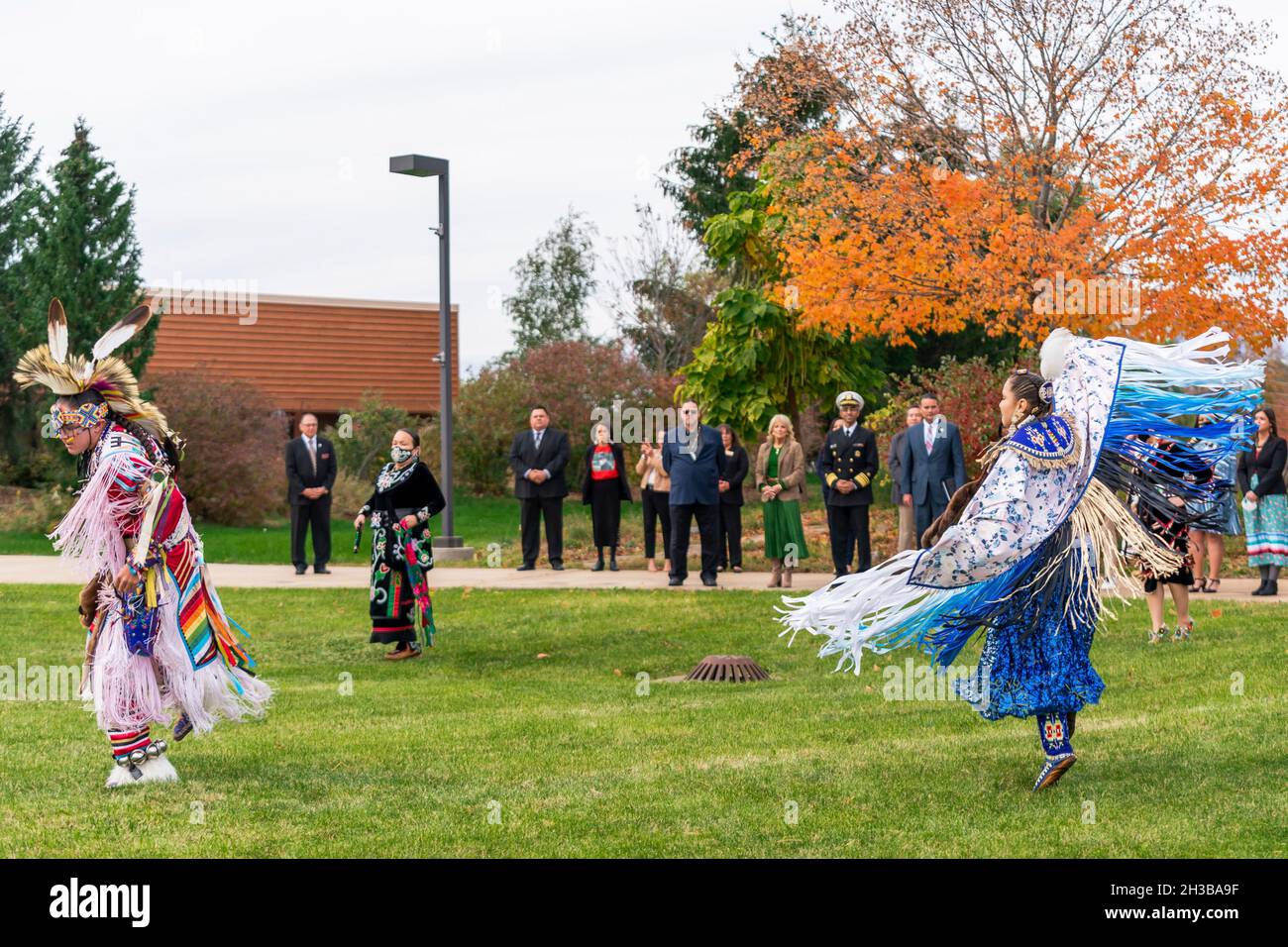Mount Pleasant, United States of America. 24 October, 2021. U.S First Lady Dr. Jill Biden, center left, and Surgeon General Vivek Murthy, center right, watch a traditional dance performance during a visit to the Saginaw Chippewa Indian Tribe October 24, 2021 in Mount Pleasant, Michigan.  Credit: Erin Scott/White House Photo/Alamy Live News Stock Photo