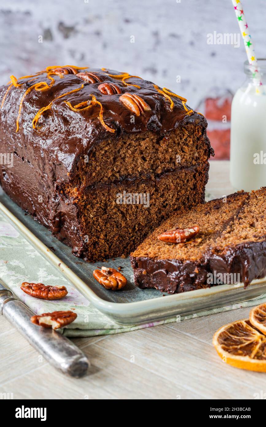 Homemade ginger loaf cake with plum marmalade, pecan nuts and chocolate