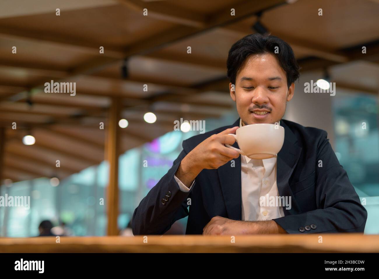 Portrait of Asian businessman sitting at restaurant and drinking coffee Stock Photo