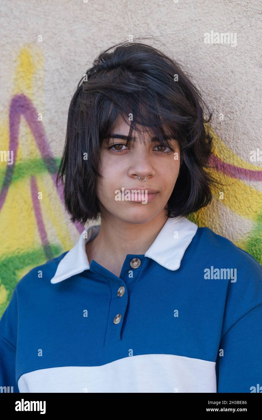 Beautiful teenage girl posing against wall with graffiti Stock Photo