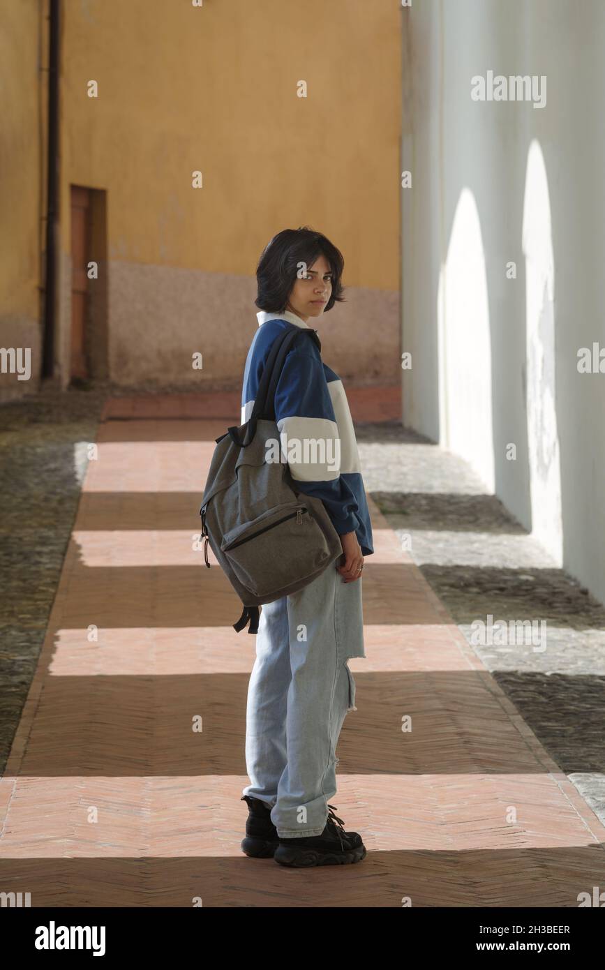 Teenage student with backpack walking on the street, Italy Stock Photo