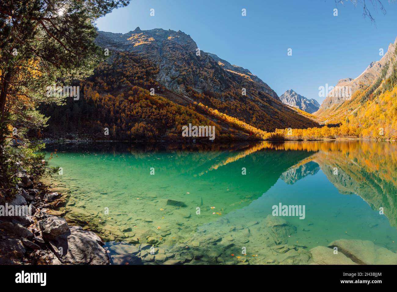 Mountain lake with transparent water and autumnal trees Stock Photo - Alamy