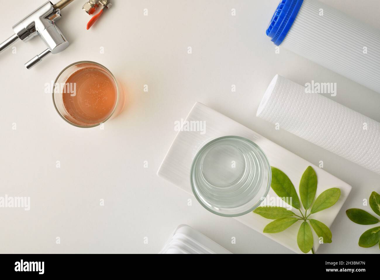 Comparison of dirty water and filtered by osmosis in glasses on a kitchen bench with filter and equipment. Top view. Horizontal composition. Stock Photo