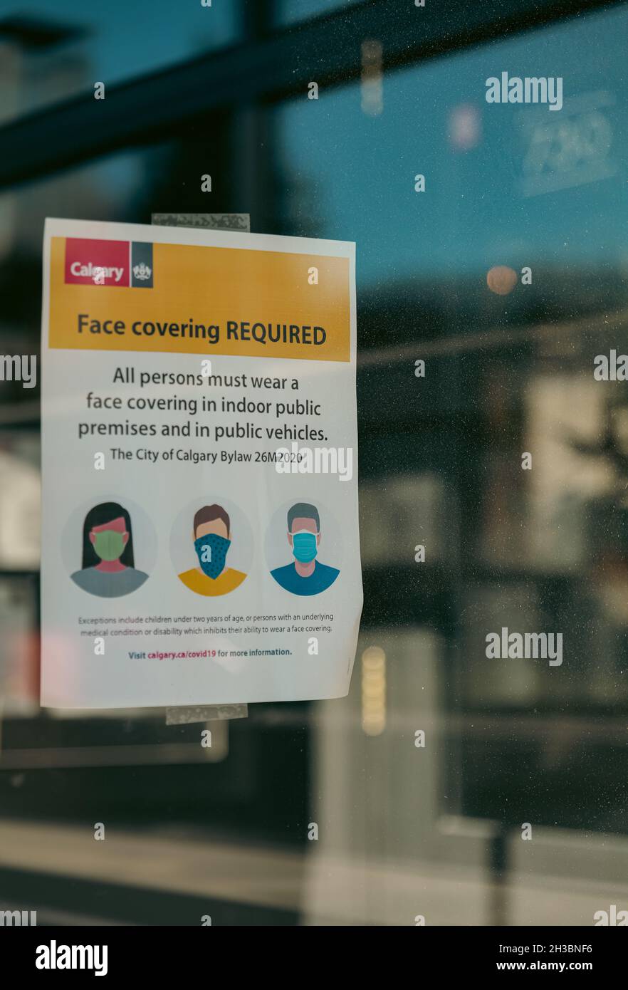 CALGARY, CANADA - Oct 26, 2021: City of Calgary Covid-19 Face mask bylaw posted outside of a local restuarant. Stock Photo