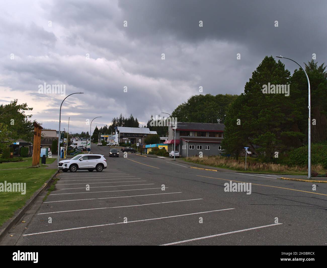 View of Market St in the downtown of Port Hardy, Vancouver Island with cars, buildings and trees on cloudy day in autumn season. Stock Photo