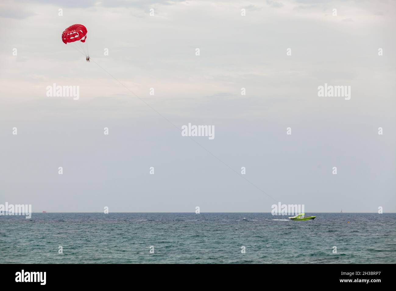 Parasailing in Agia Napa bay, motor boat and red parachute Stock Photo