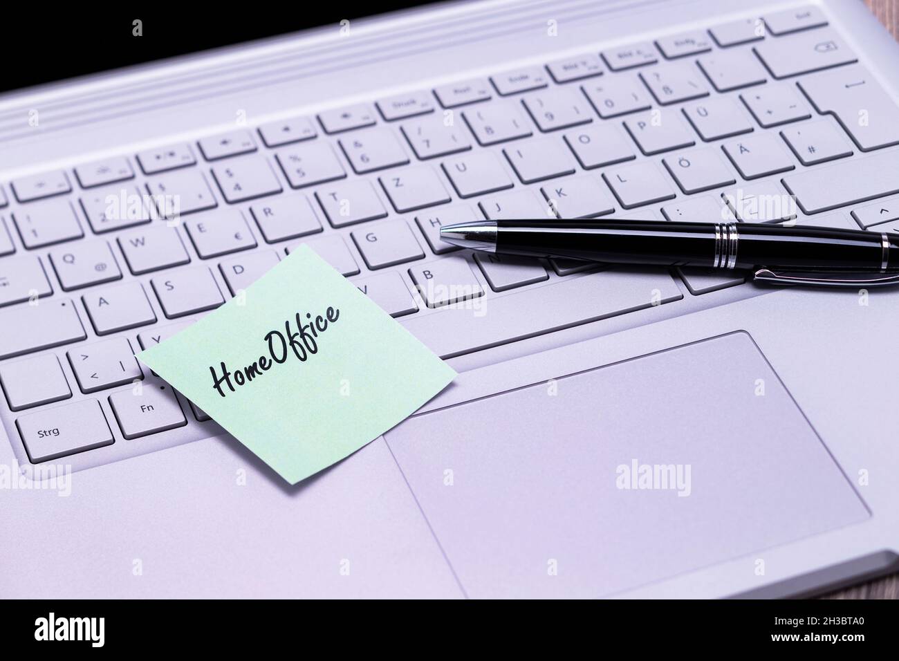 The photo shows a note with the text home office on a notebook computer Stock Photo