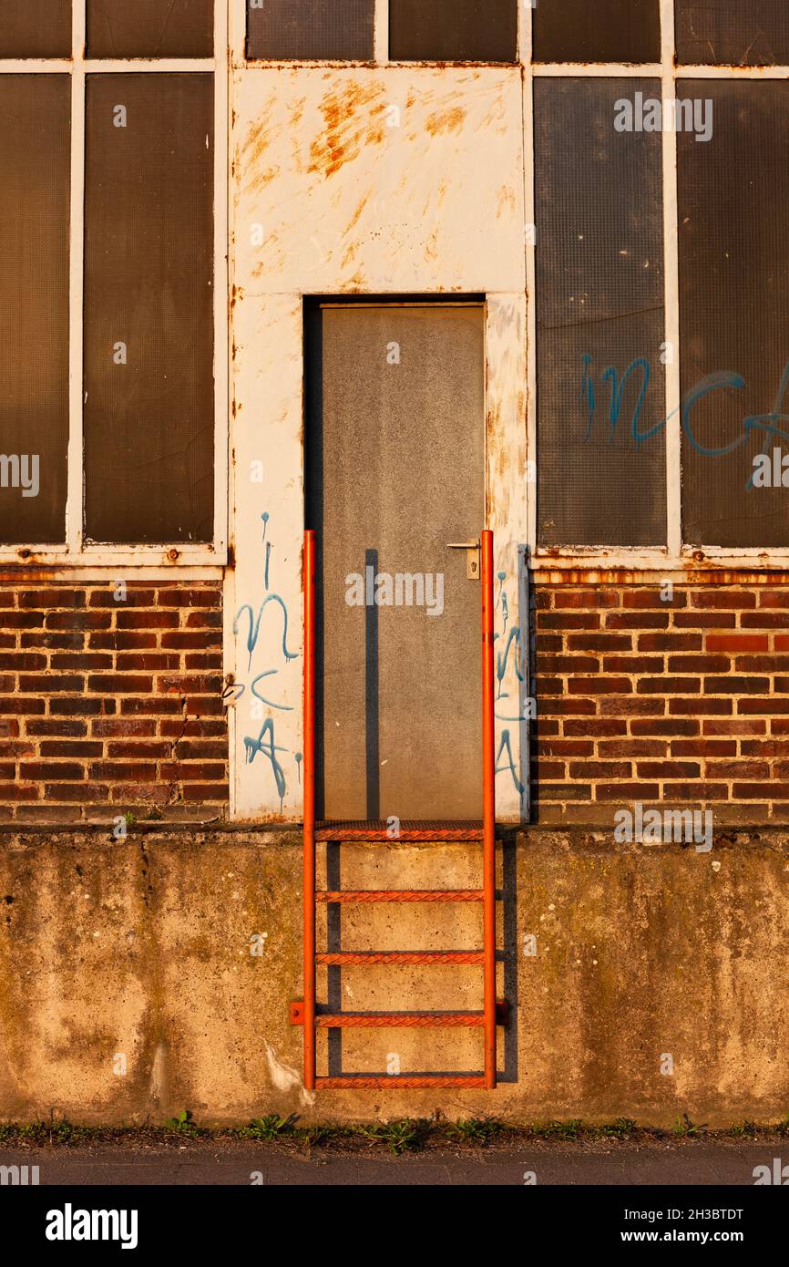 The photo shows the entrance to a warehouse with a metal ladder Stock Photo