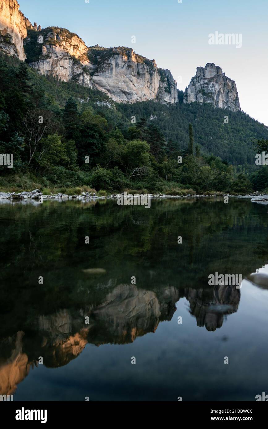 Vertical shot of the high rocky mountains reflecting in the lake on a ...