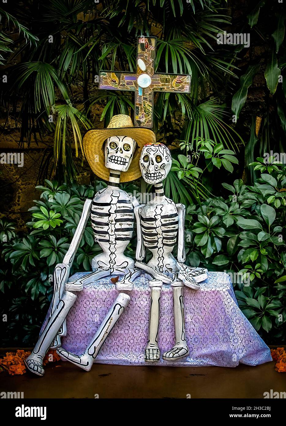 Traditional mexican day of the dead display, a couple of skeletons sitting in a bank Stock Photo