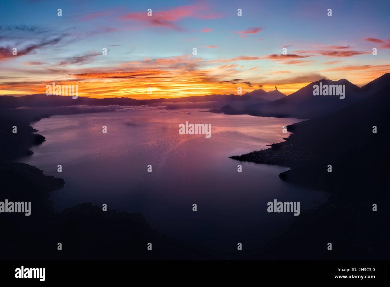 Sunrise over Lake Atitlan with Fuego, Acatenango, Toliman, and Atitlan volcanoes, Lago Atitlan, Guatemala Stock Photo