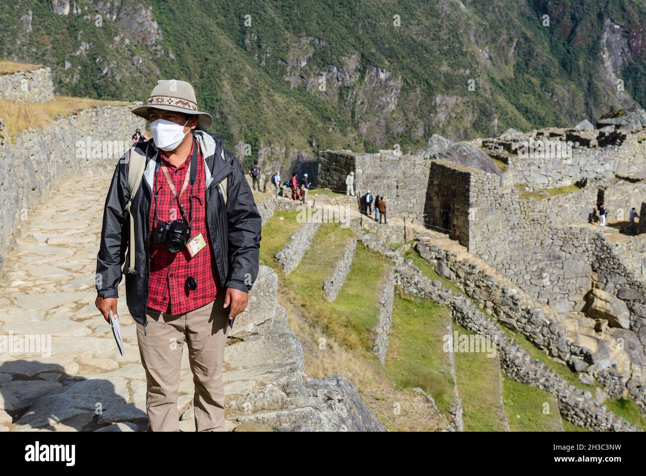 A local culture guide leads the tour of Machu Picchu. Cuzco, Peru. Stock Photo