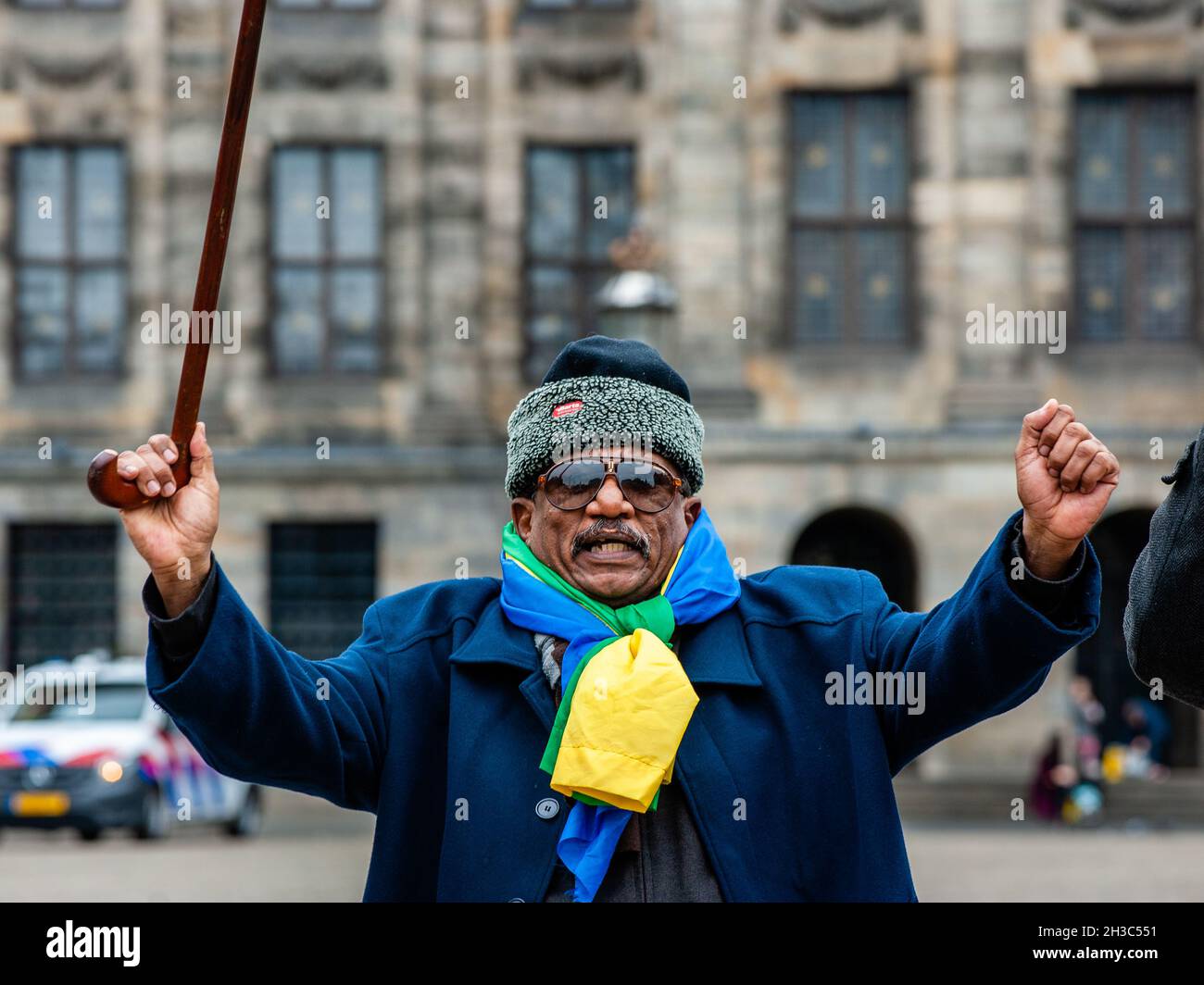 A Sudanese man holds up a walking stick during the demonstration.Sudanese  people living in The Netherlands gathered at the Dam Square in the city  center of Amsterdam to protest against the military