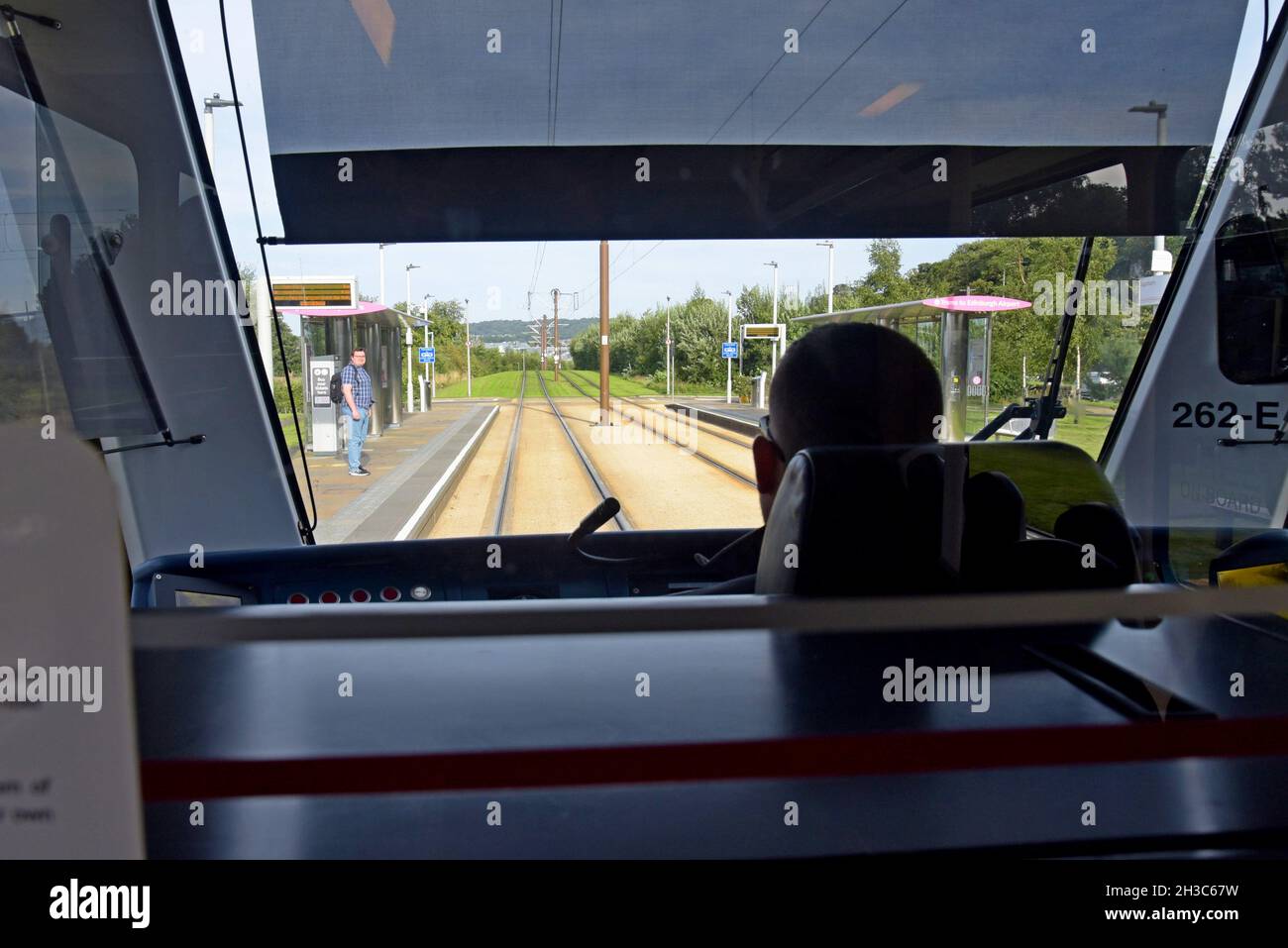 A view of the driving cab and drivers view from an Edinburgh tram approaching a tram stop. - Stock Image