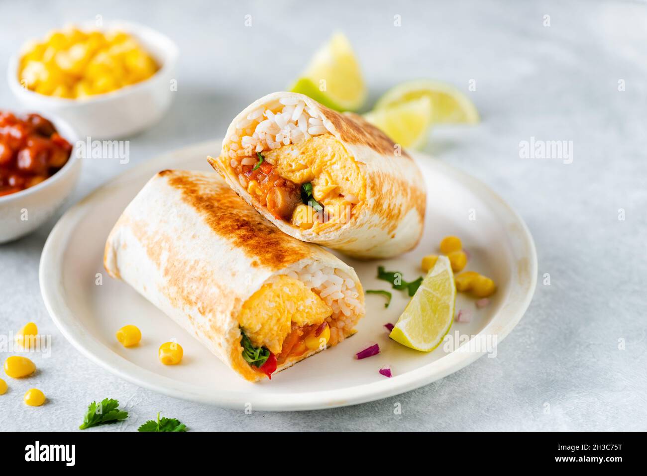Breakfast tortilla wrap with omelet, beans and vegetables. No meat burrito sandwich Stock Photo