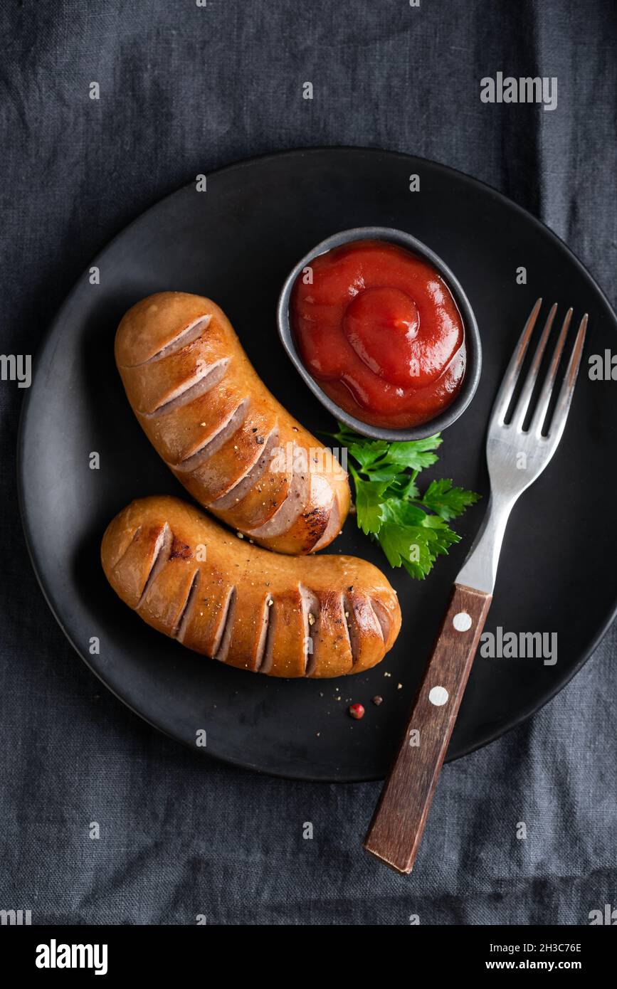 Barbecue sausages on black plate served with tomato sauce ketchup. Top view Stock Photo Alamy