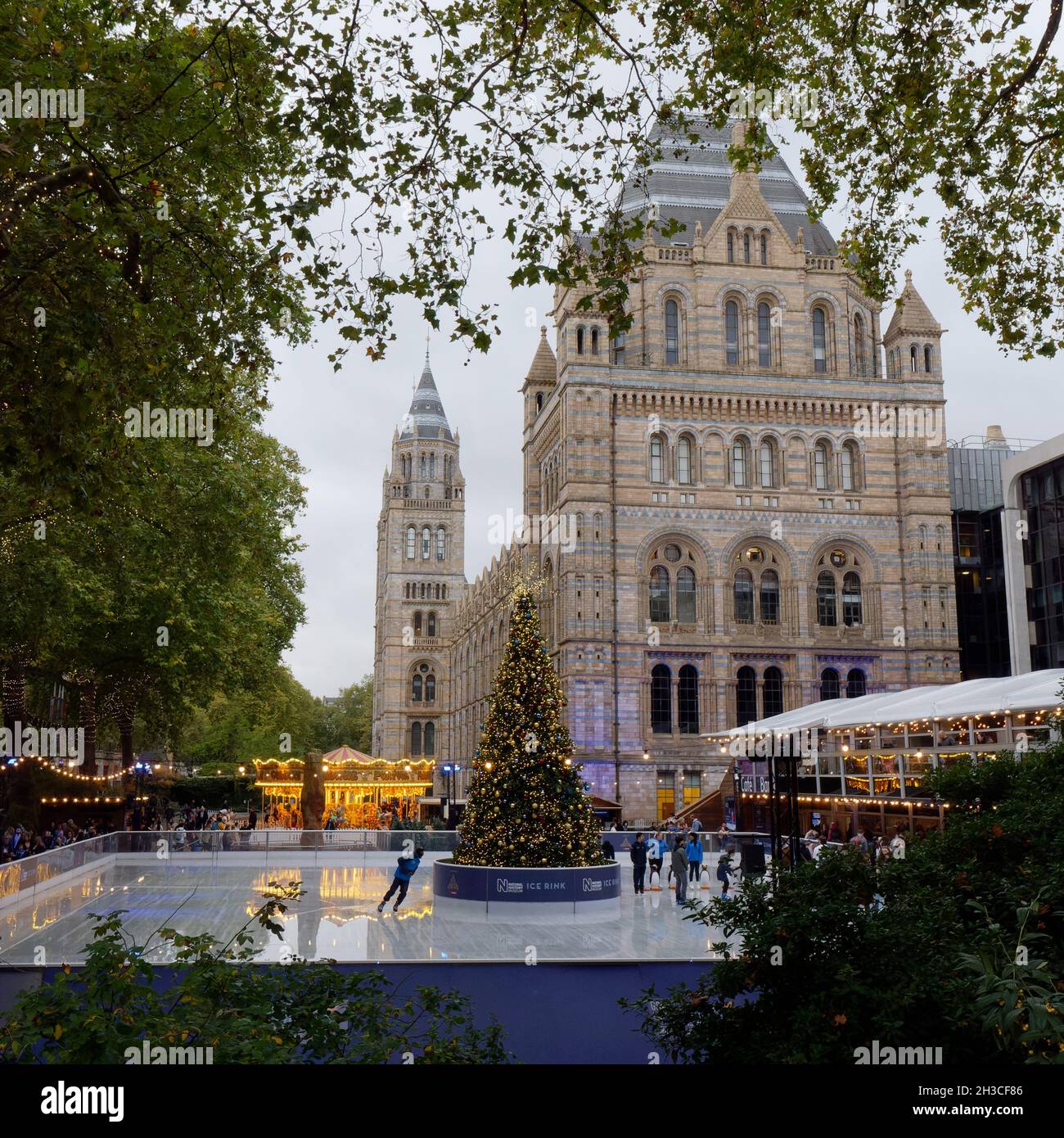 London, Greater London, England, October 26 2021: festive Ice Rink at the National History Museum with Christmas Tree and Merry Go Round. Stock Photo