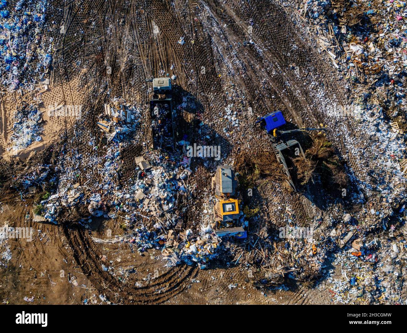 Garbage dump and working dump truck and bulldozer, aerial top view ...