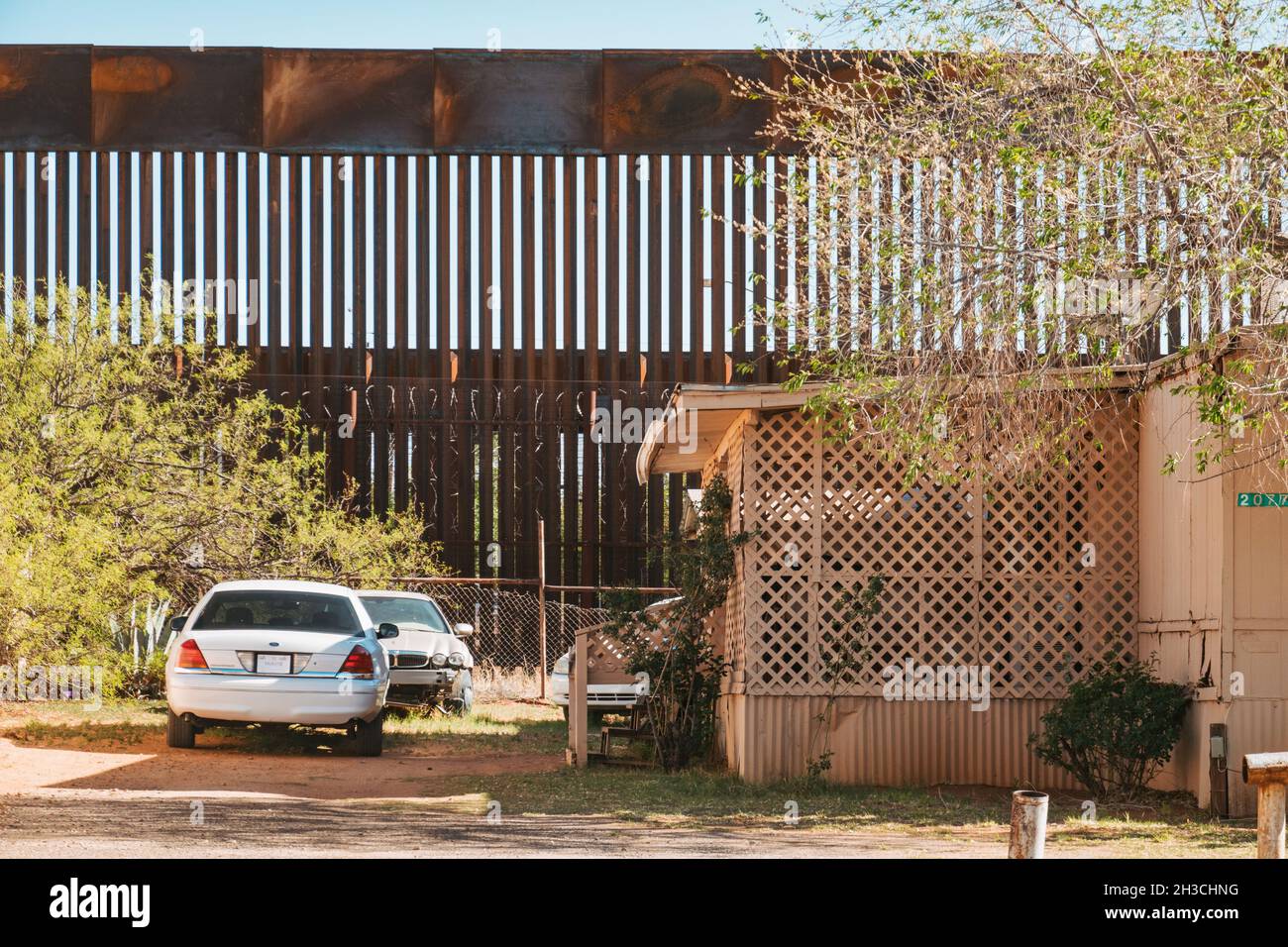 Cars parked in the yard of a house in front of the USMexico border