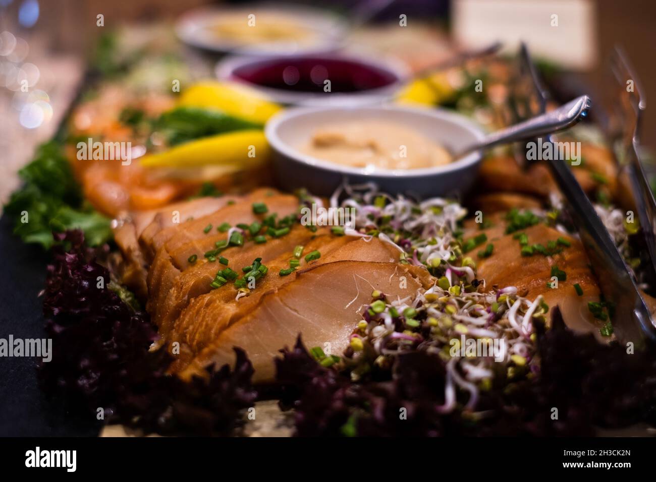 Cold smoked butterfish fillet with smoky honey sauce. Delicious professional looking food and snacks served at catering event or party buffet style. Stock Photo