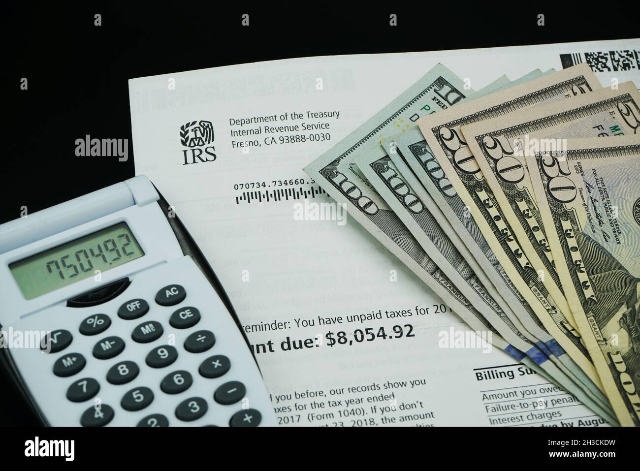 Lale Elsinore, CA - October 26, 2021: IRS tax bill with US currency and calculator Stock Photo