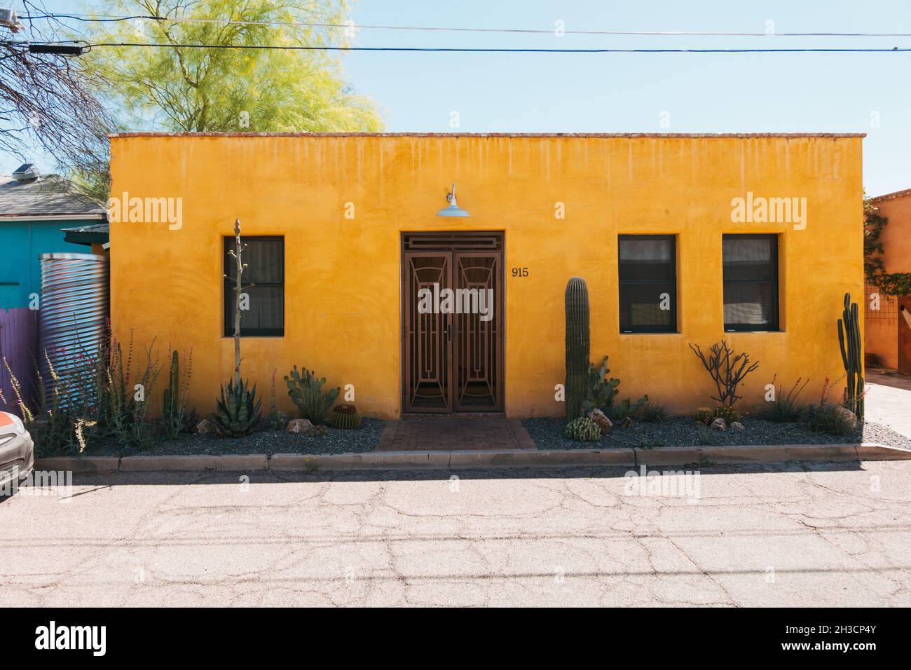 A vibrant yellow oblong-shaped adobe home in Barrio Viejo, Tucson, AZ Stock Photo