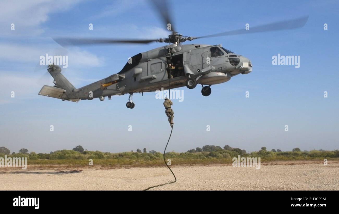 NAVAL STATION ROTA, Spain (Sept. 30, 2021) A Marine assigned to Fleet Anti-Terrorism Security Team Company, Europe, fast-ropes out of a Spanish SH-60B Seahawk helicopter during exercise Lisa Azul, Sept. 30, 2021. Lisa Azul is a joint nation exercise between the U.S. and Spanish expeditionary forces designed to strengthen capabilities and interoperability through information exchanges and combined operations. (U.S. Navy photo by Mass Communication Specialist 1st Class Caine Storino) Stock Photo