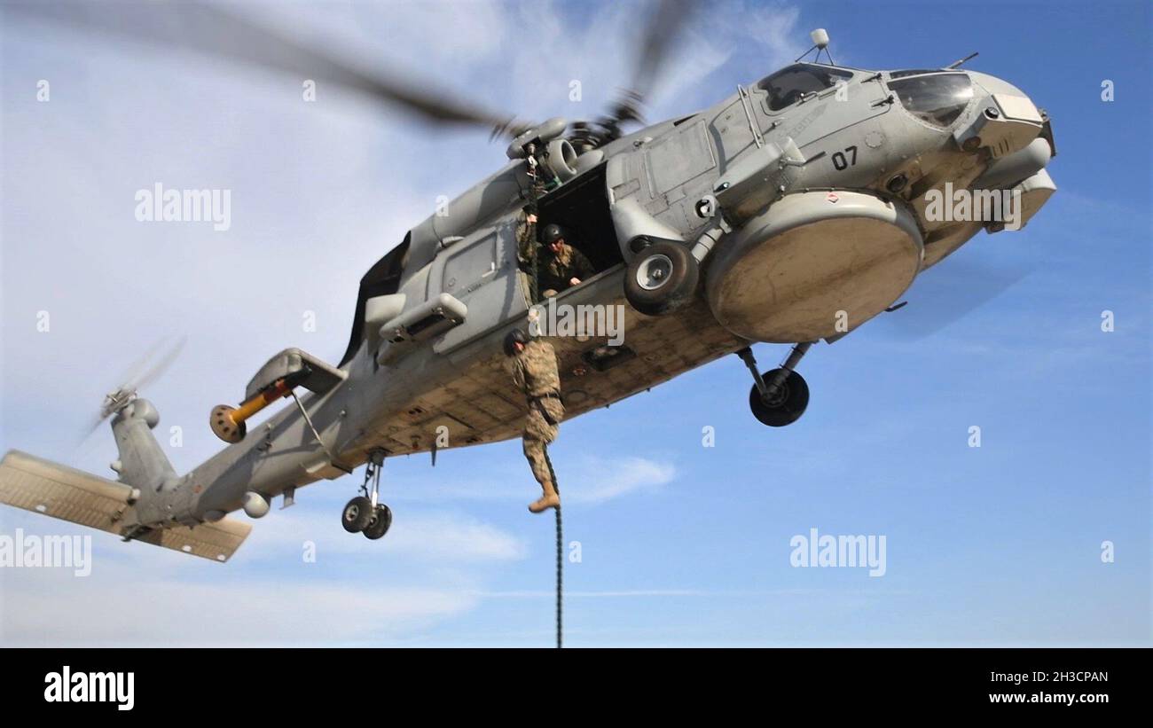 NAVAL STATION ROTA, Spain (Sept. 30, 2021) A Marine assigned to Fleet Anti-Terrorism Security Team Company, Europe, fast-ropes out of a Spanish SH-60B Seahawk helicopter during exercise Lisa Azul, Sept. 30, 2021. Lisa Azul is a joint nation exercise between the U.S. and Spanish expeditionary forces designed to strengthen capabilities and interoperability through information exchanges and combined operations. (U.S. Navy photo by Mass Communication Specialist 1st Class Caine Storino) Stock Photo